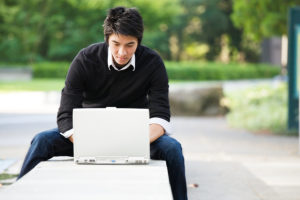 Sports Psychology student studying outside on laptop