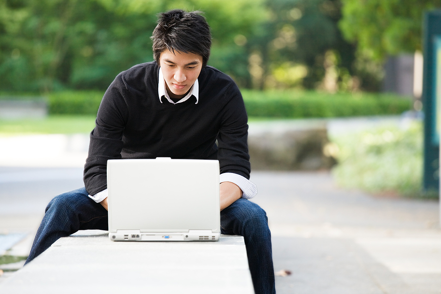 Sports Psychology student studying outside on laptop